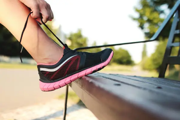 chaussures running femme qui fait ses lacets